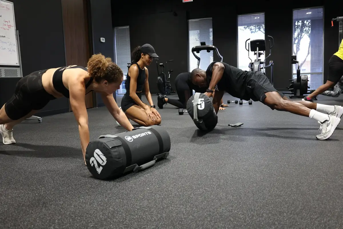 Members working through a floor circuit together during a group class