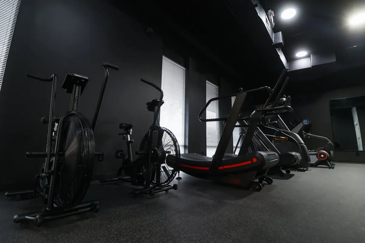 Racked dumbbells and benches along the strength wall